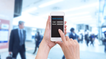 Hand holding smartphone with Mobile Banking login screen on blur