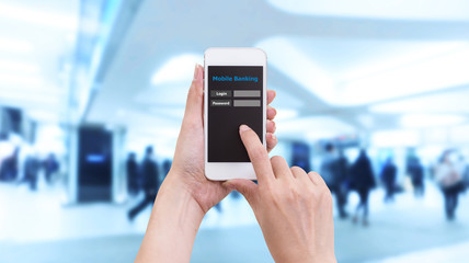 Hand holding smartphone with Mobile Banking login screen on blur