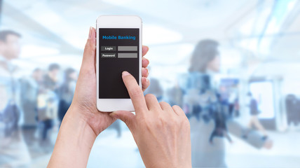 Hand holding smartphone with Mobile Banking login screen on blur