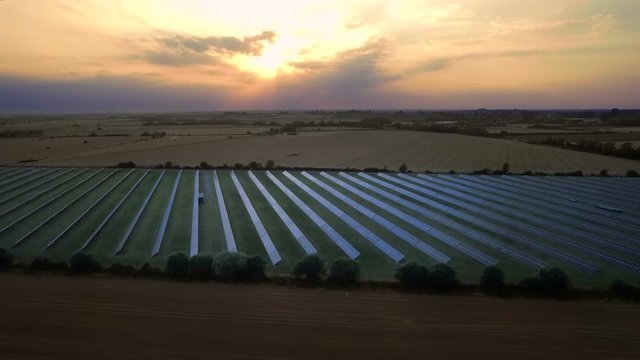 Solar farm in the sunset. Aerial pan shot