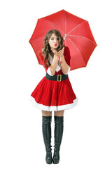 Santa woman under umbrella blowing air kiss at camera. Full body length portrait isolated over white studio background.