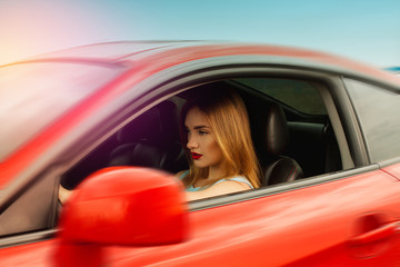 Fototapeta na wymiar young woman with red lips driving a car