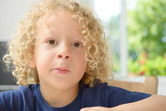 portrait of a little boy with blond curly hair