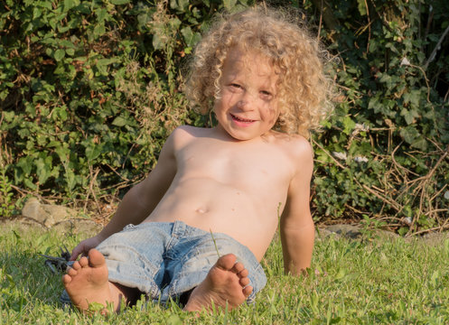 little boy shirtless playing in the garden