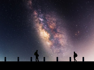 Naklejka na ściany i meble Galactic beautiful landscapes, travelers on the path that the Milky Way galaxy and the background light of the stars across the night sky.