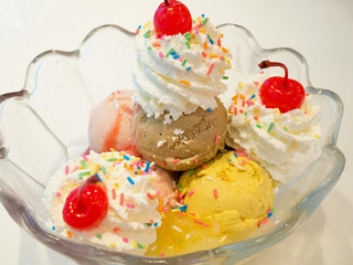 Ice cream scoops with whipped cream and cherry