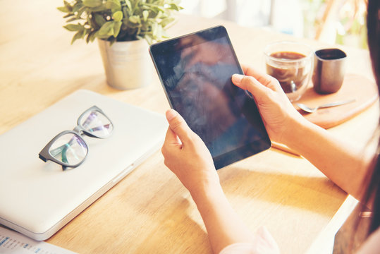 Beautiful Business Working Woman Using Ipad While Working With Laptop And Reading Report , Graphs , Charts, Document At Work. Prowander Business Woman Working At Her Desk.