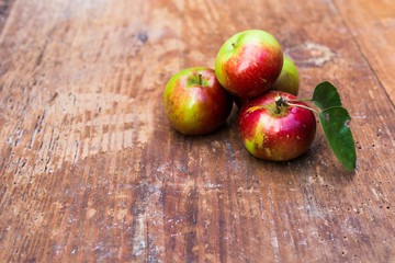 Red ripe apples at dark wooden table.