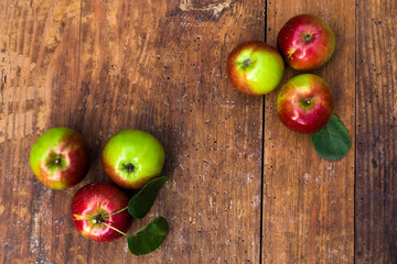 Red ripe apples at dark wooden table.