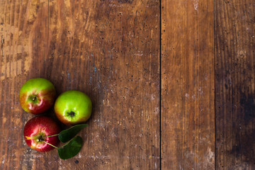 Red ripe apples at dark wooden table.