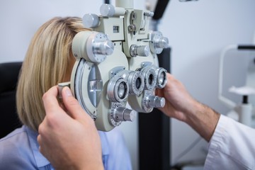 Naklejka premium Patient under going eye test through phoropter
