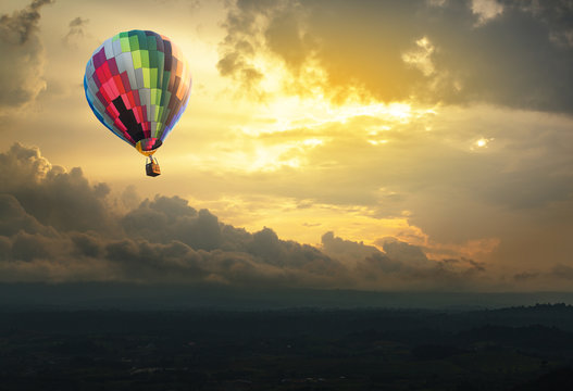 Hot air balloon over the hill at sunset