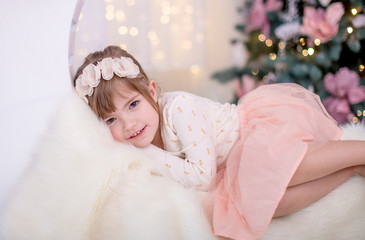 Obraz na płótnie Canvas little girl asleep on fur against the background of Christmas lights