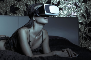 Sexy woman in underwear using VR glass in bed in dark - Powered by Adobe