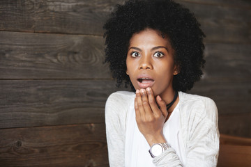 Human emotions and feelings. Close-up portrait of suprised African American female student with...