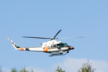 White-orange helicopter is flying