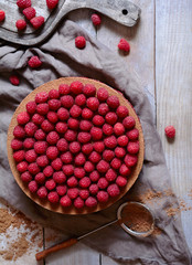 Homemade delicious chocolate cake cheesecake with fresh raspberries on the rustic wooden table. Horizontal top view.