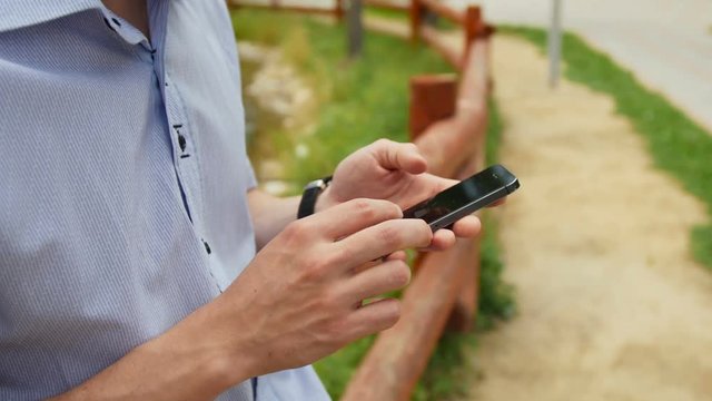 Man using mobile smart phone in park, iphon style.