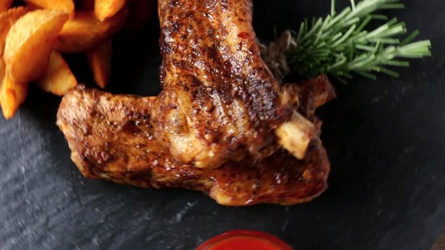 baked pork ribs with baked potato and red sauce