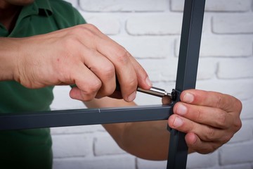 Closeup photo of handyman tightening the screws