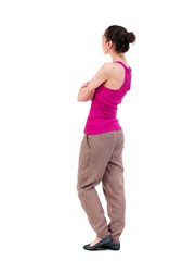 back view of standing young beautiful woman. dark-skinned girl in a red T-shirt standing sideways with his arms crossed.