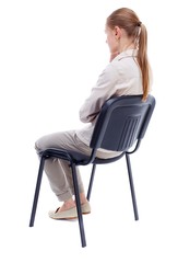 back view of young beautiful woman sitting on chair. girl watching. Skinny girl in white denim suit sidit thoughtfully in his chair.