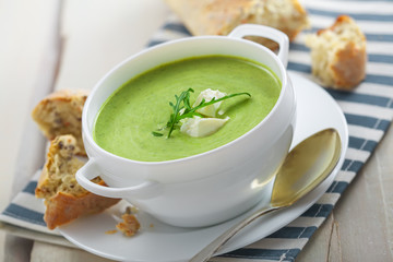 Delicious spinach cream soup with rye bread on a table. International meal.