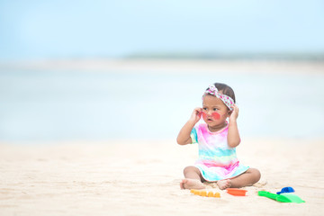baby girl playing with beach toys at the beach