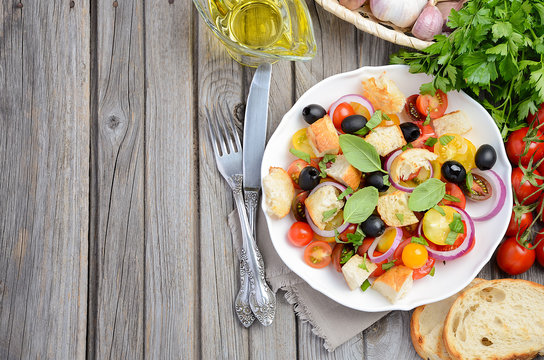 Traditional Italian Panzanella salad with fresh tomatoes and crispy bread, top view, copy space