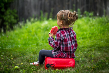 little girl eating watermelon in the summer
