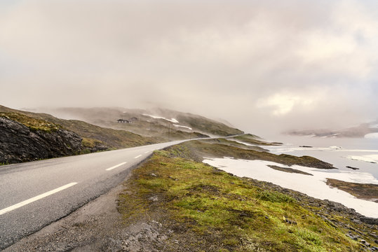 Norway, Hedmark, Tufsindalen valley, country road and clouds