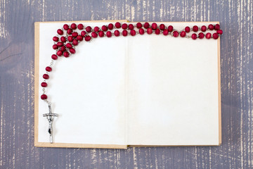 Open book and catholic rosary.