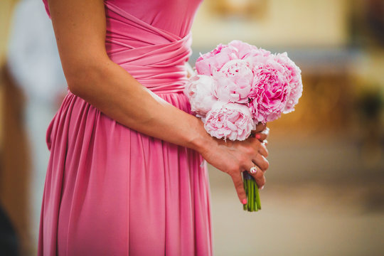a bridesmaid in a pink dress holding a pink wedding bouquet