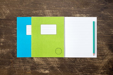 Three exercise books and pencil.