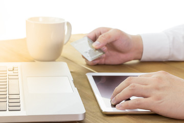 a man using his digital tablet and holding credit card intent to shopping online concept, digital business or e-commerce or e-payment. warm tone.