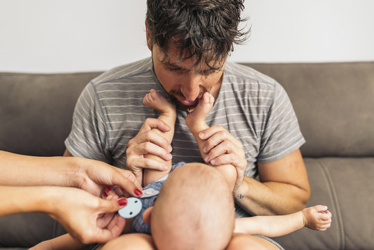 father holding tiny baby's feet