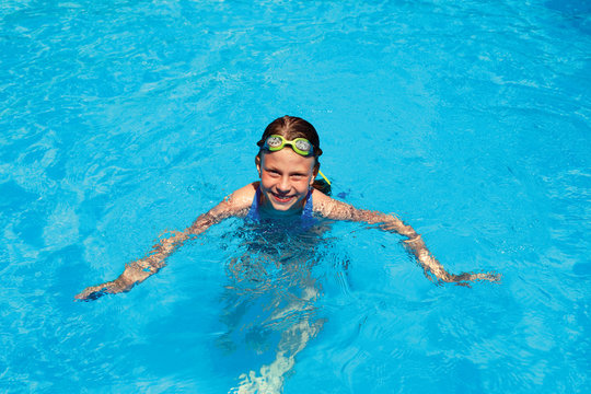 little girl swims in swimming pool