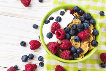 Healthy corn flakes breakfast on the white wooden table