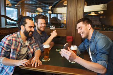 male friends with smartphone drinking beer at bar