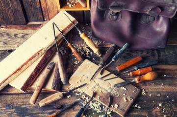 Chisels and carved piece of wood in traditional carpenter workshop