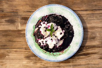 Homemade blueberry dumplings, with berry souce and sour cream, decorated with fine sugar ans mint leaf, Czech traditional sweet food