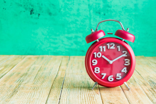 Red clock on wooden old background