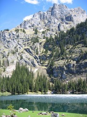 View of Hinterburgseeli lake and mountain, near Axalp, Switzerland in late Spring, with some ice still present at the far edge of the lake