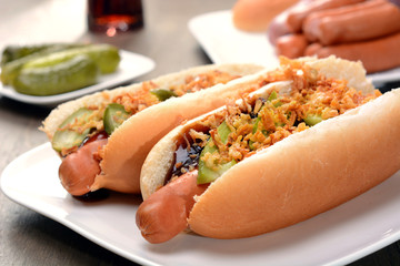 Hot Dogs im Brötchen mit Röstzwiebeln, Gürkchen, Ketchup und Cola