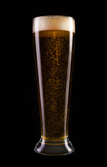 Glass of fresh beer with gas bubbles on a black background.