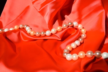 roter, weicher luxuriöser Stoff in Falten gelegt mit Perlen 