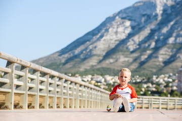 Small cute boy is playing toys in port