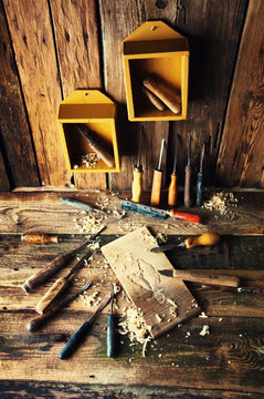 Chisels and carved piece of wood in traditional carpenter workshop