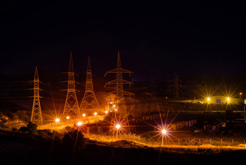 Electric transmission pylons at night