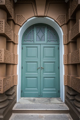 HDR view of Closed green wooden door in European style with Brown building